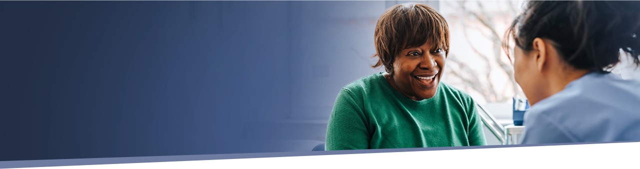 woman smiling while speaking with her healthcare provider about IMDELLTRA® treatment