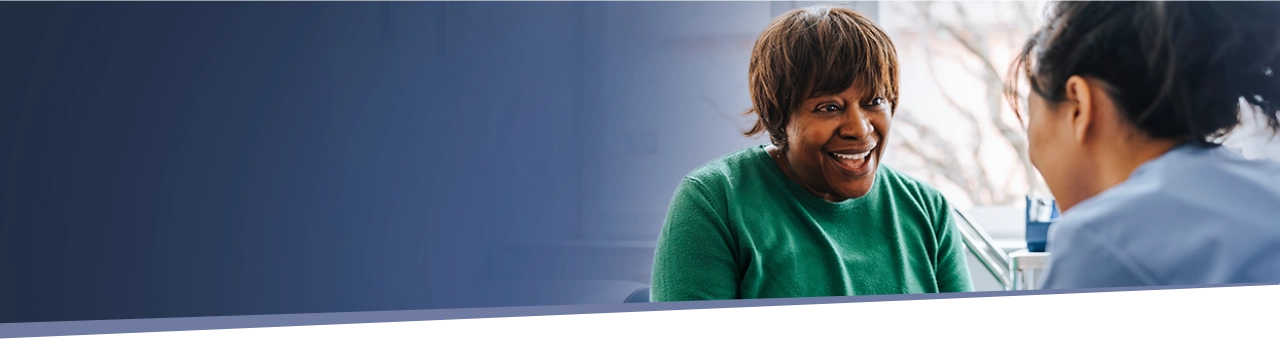woman smiling while speaking with her healthcare provider about IMDELLTRA® treatment