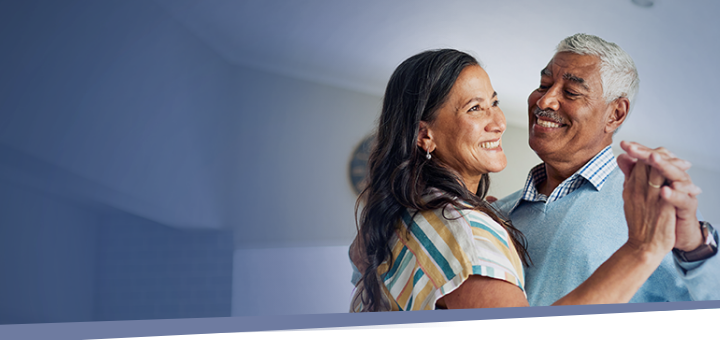 older couple smiling and dancing together indoors during IMDELLTRA® treatment  