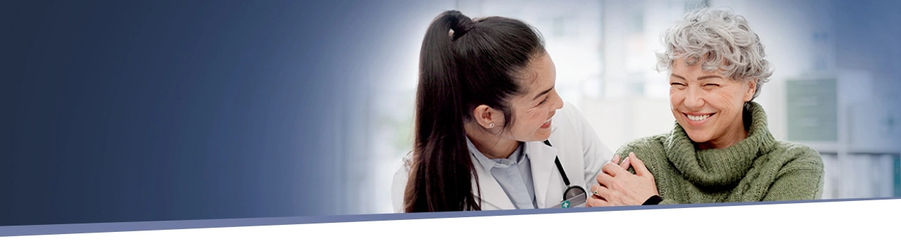 older woman smiling while speaking with her healthcare provider about IMDELLTRA® treatment
